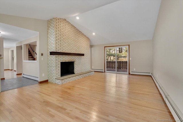 unfurnished living room with a baseboard radiator, light hardwood / wood-style floors, and a brick fireplace