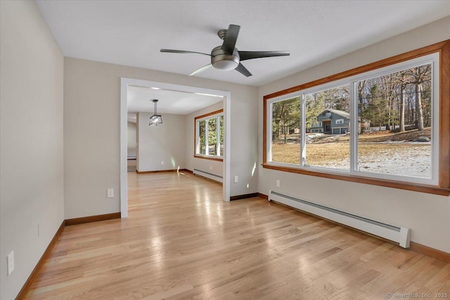 spare room featuring ceiling fan, a baseboard radiator, and light hardwood / wood-style flooring