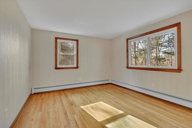 unfurnished room featuring a baseboard radiator and light wood-type flooring