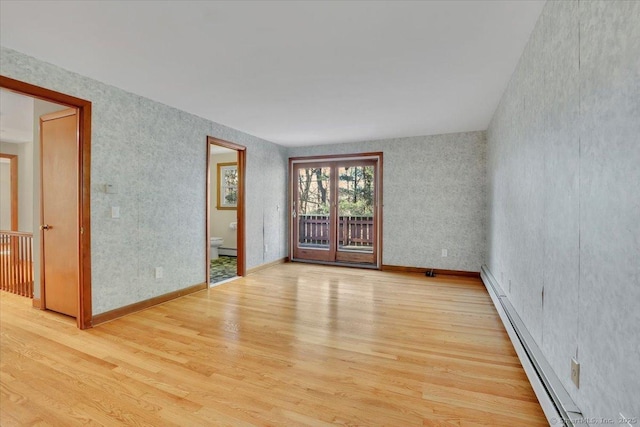 spare room with a baseboard radiator and light wood-type flooring