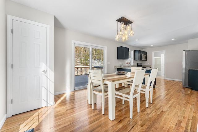 dining space featuring light wood-style flooring, a chandelier, baseboards, and recessed lighting