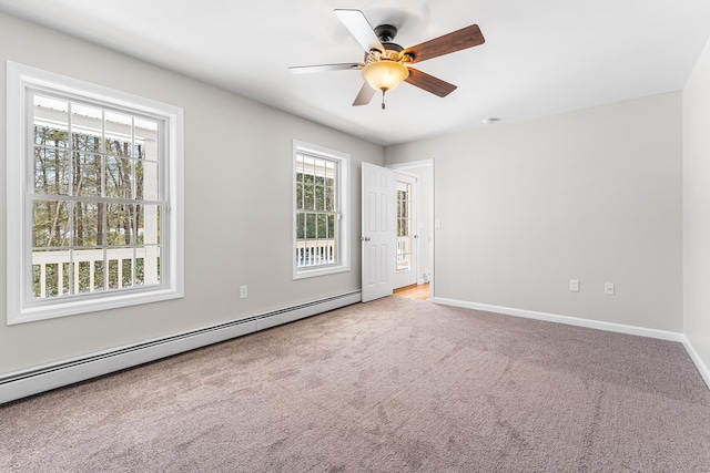 spare room with a baseboard radiator, baseboards, ceiling fan, and carpet