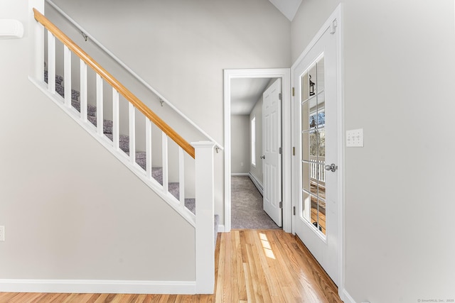 entrance foyer featuring stairway, baseboards, and wood finished floors