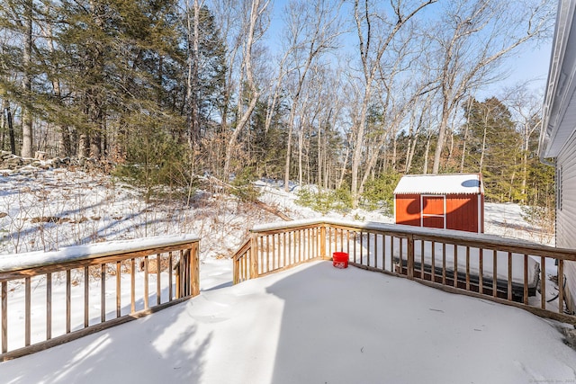 snow covered deck with a storage unit and an outdoor structure