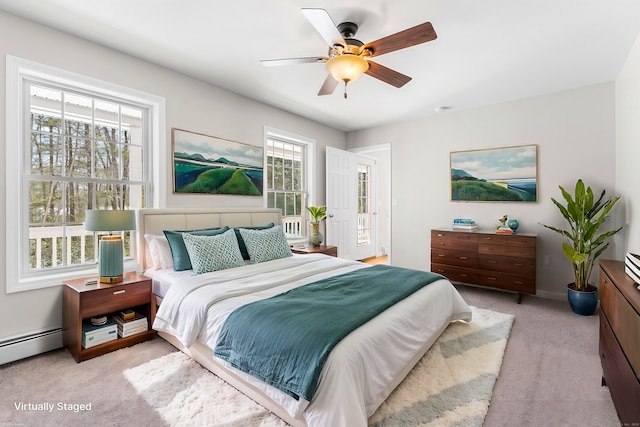 bedroom featuring a baseboard heating unit, light colored carpet, ceiling fan, and baseboards