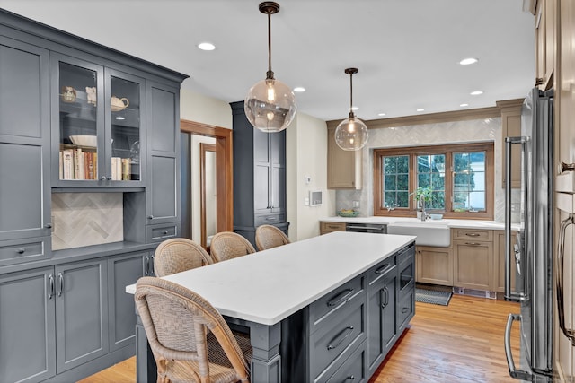 kitchen with sink, gray cabinets, hanging light fixtures, and a center island