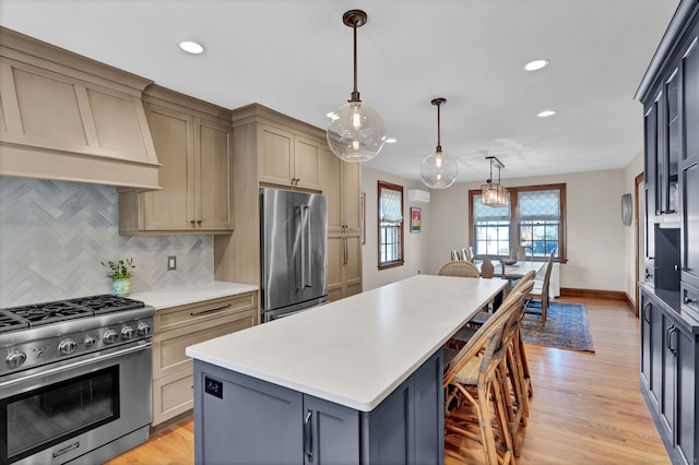 kitchen featuring gray cabinets, a kitchen island, decorative light fixtures, premium appliances, and decorative backsplash