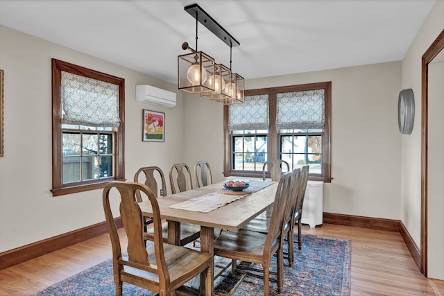 dining space featuring an AC wall unit, plenty of natural light, and light hardwood / wood-style floors