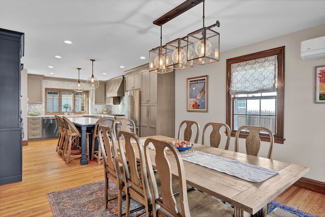 dining area featuring light hardwood / wood-style floors and a wall unit AC