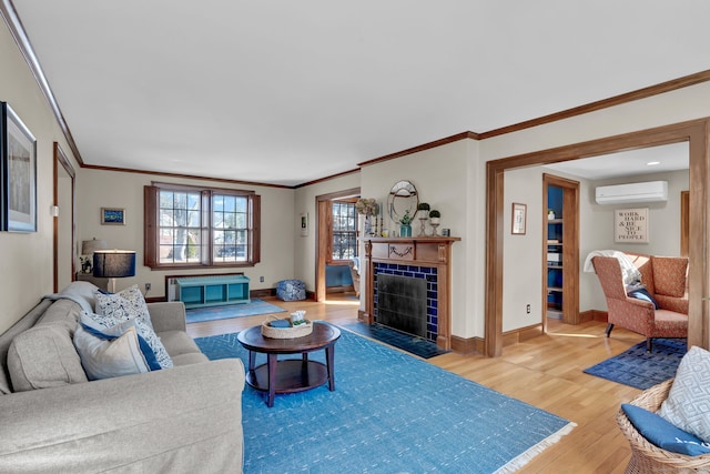 living room with a tiled fireplace, wood-type flooring, ornamental molding, and a wall mounted AC