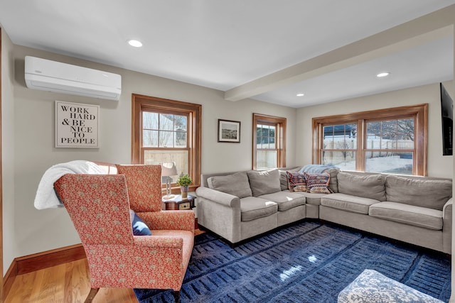 living room featuring hardwood / wood-style flooring, a wall unit AC, and beam ceiling