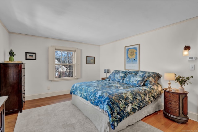 bedroom with ornamental molding and light hardwood / wood-style flooring