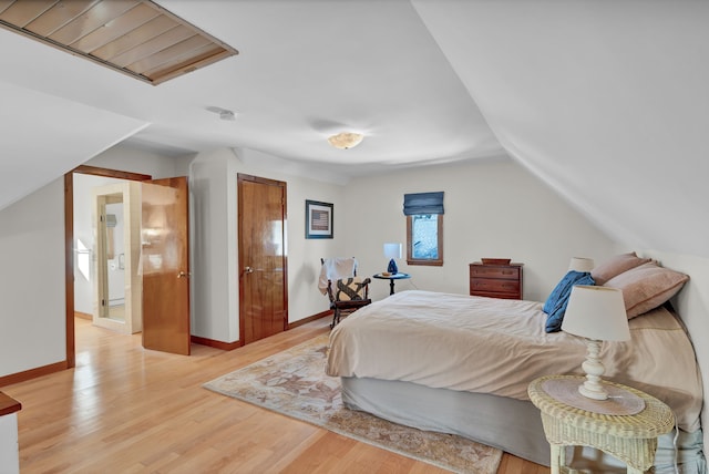 bedroom with lofted ceiling and light hardwood / wood-style flooring