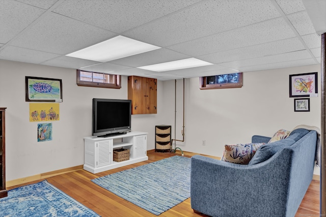 living room with a drop ceiling and light hardwood / wood-style flooring