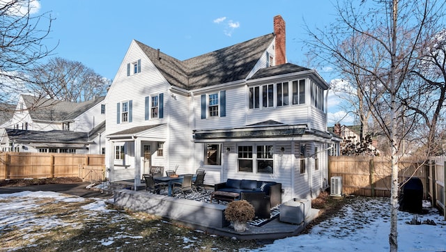 snow covered back of property featuring outdoor lounge area