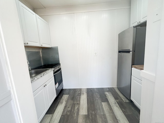 kitchen featuring sink, white cabinets, dark hardwood / wood-style flooring, decorative backsplash, and stainless steel appliances