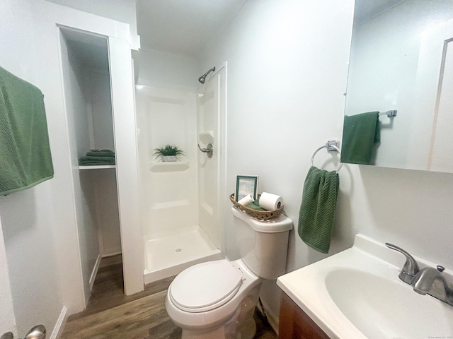 bathroom with vanity, wood-type flooring, toilet, and a shower