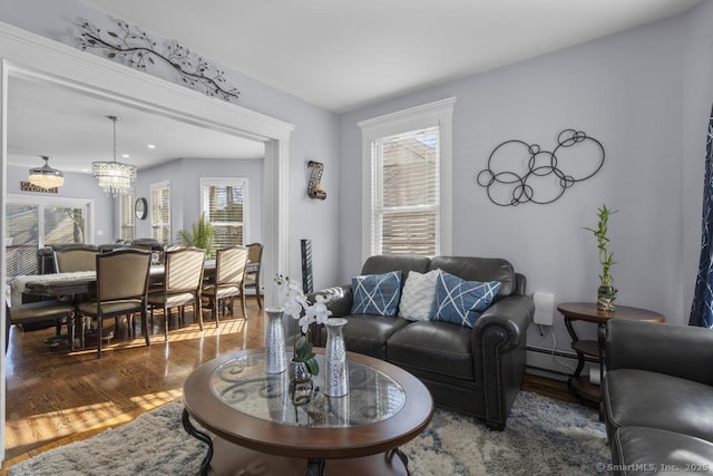 living room featuring dark hardwood / wood-style flooring, a notable chandelier, and baseboard heating