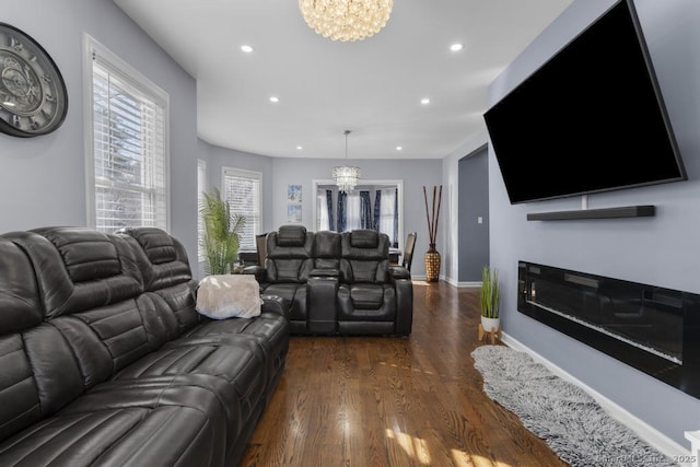 living room featuring an inviting chandelier and dark hardwood / wood-style floors