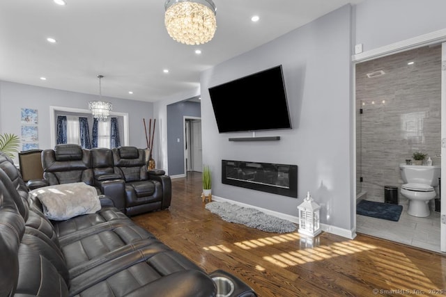 living room with dark hardwood / wood-style floors and a notable chandelier