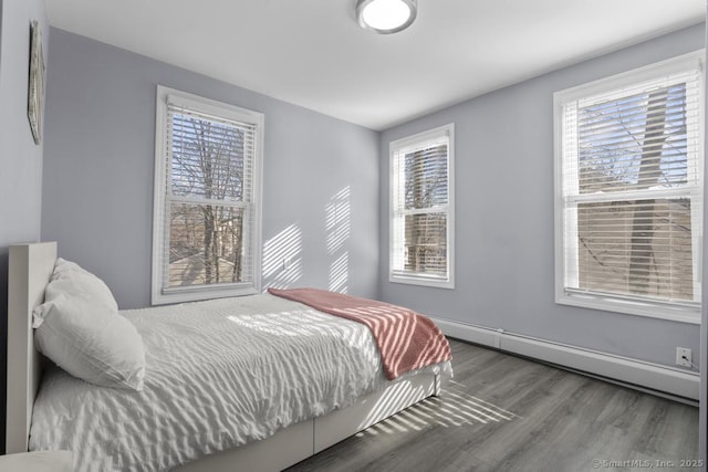 bedroom with wood-type flooring and baseboard heating