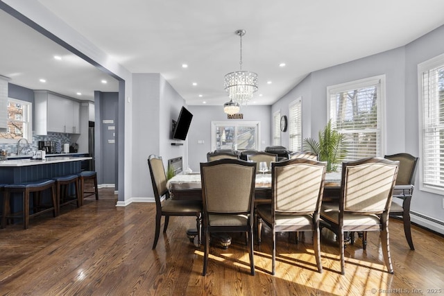 dining room with an inviting chandelier, plenty of natural light, and dark hardwood / wood-style floors