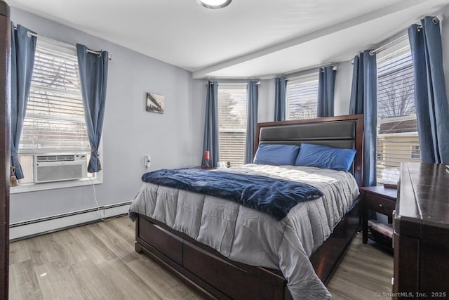 bedroom with a baseboard radiator, cooling unit, and light hardwood / wood-style floors