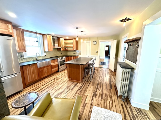 kitchen with sink, decorative light fixtures, a kitchen breakfast bar, a kitchen island, and stainless steel appliances