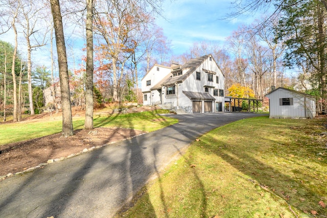 view of front of home with a front yard and a storage unit