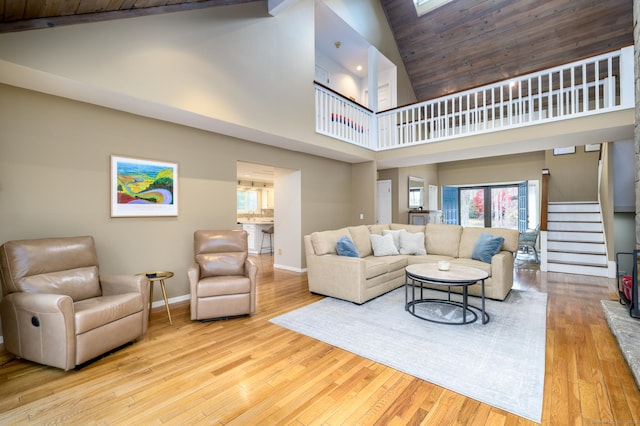 living room featuring a towering ceiling and light wood-type flooring