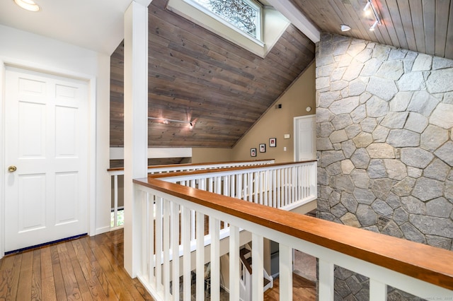 corridor featuring hardwood / wood-style flooring, vaulted ceiling with beams, and wooden ceiling