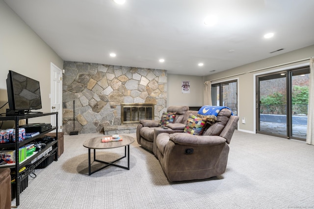 living room with light carpet and a stone fireplace