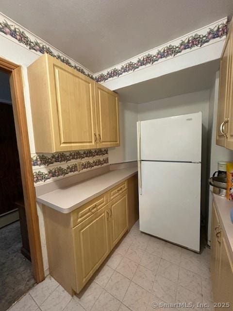 kitchen featuring light brown cabinets and white refrigerator