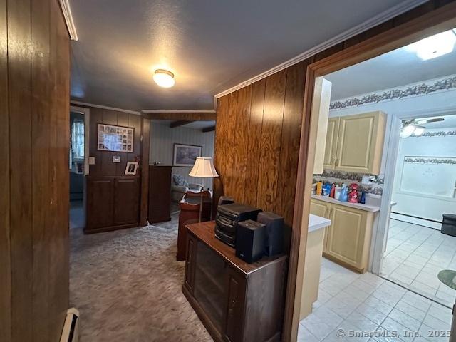 corridor featuring a baseboard heating unit and ornamental molding