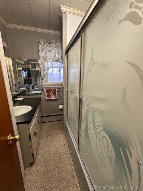 bathroom with walk in shower, ornamental molding, vanity, and a baseboard radiator