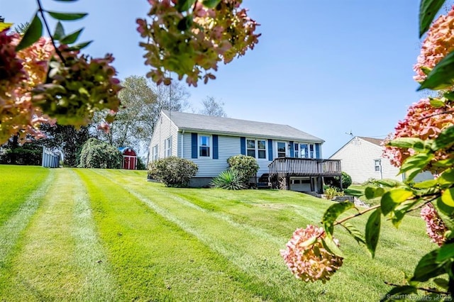 view of front facade featuring a deck, driveway, and a front lawn