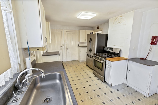 kitchen featuring stainless steel appliances, sink, and white cabinets