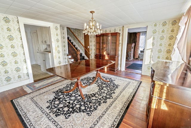 dining area with hardwood / wood-style flooring and a notable chandelier