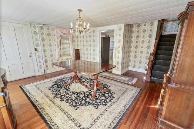 dining room with dark hardwood / wood-style floors and a chandelier