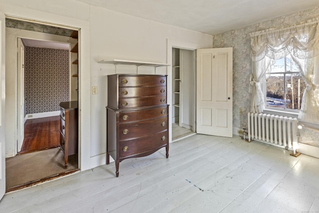 bedroom with radiator and hardwood / wood-style flooring