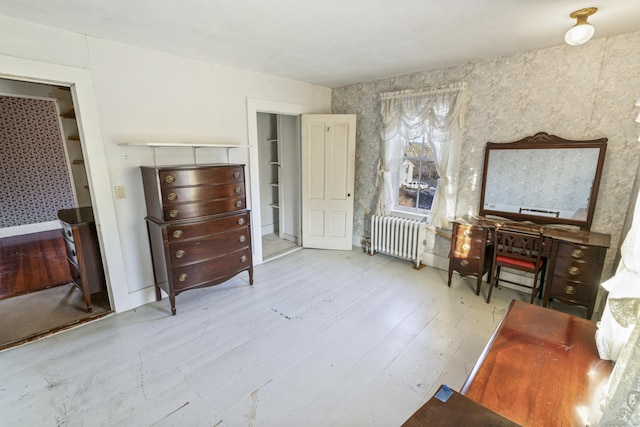 bedroom featuring radiator heating unit and light wood-type flooring