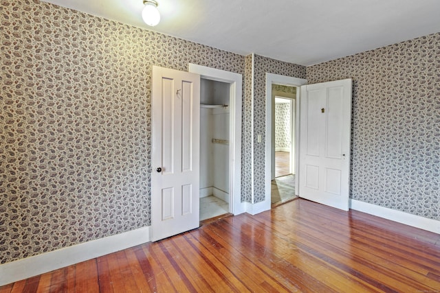 unfurnished bedroom featuring wood-type flooring and a closet