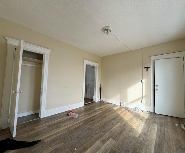 unfurnished bedroom with dark wood-type flooring and a textured ceiling