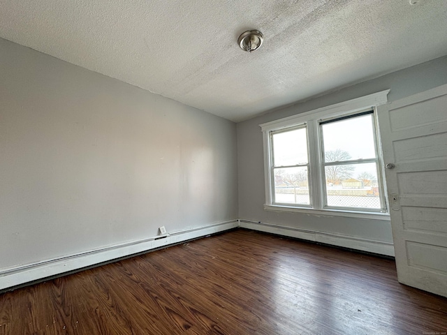 empty room with dark hardwood / wood-style flooring, a textured ceiling, and baseboard heating