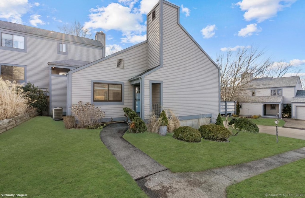 view of home's exterior featuring central air condition unit, a yard, and a garage