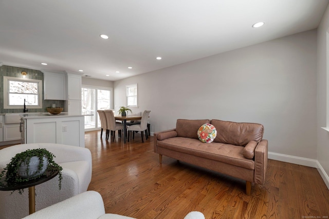 living room with a healthy amount of sunlight, dark hardwood / wood-style flooring, and sink