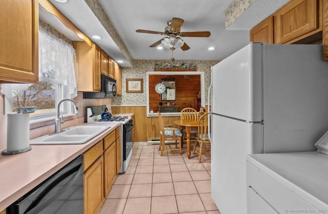 kitchen featuring washer / dryer, sink, light tile patterned floors, ceiling fan, and black appliances