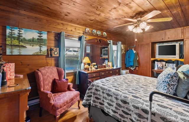 bedroom with wood-type flooring, wooden ceiling, baseboard heating, and wood walls