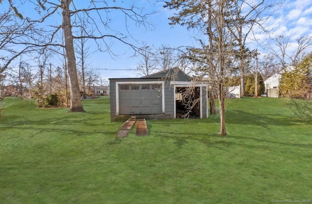 view of yard with a garage and an outbuilding