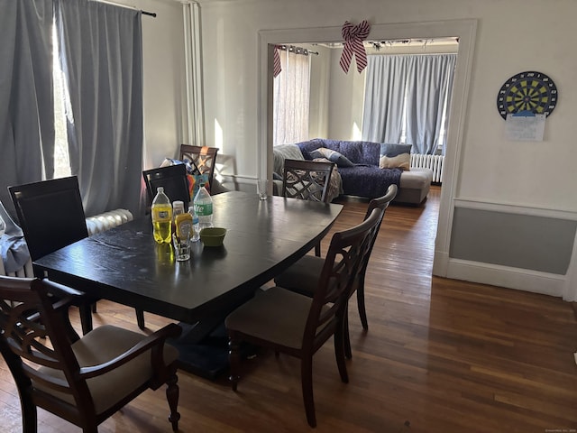 dining room with hardwood / wood-style flooring and radiator heating unit